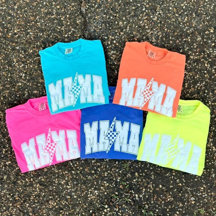 Limited Edition Mama Neon Lightning Tees – Vitamin Sea Boutique LLC Neon Shirts Ideas, Neon Tops With Graphic Print For Summer, Neon Graphic Print Top For Summer, Casual Neon Crew Neck Top, Casual Neon Cotton Tops, Casual Cotton Top With Glow In The Dark Details, Casual Cotton Glow In The Dark Tops, Casual Neon Tops With Letter Print, Trendy Neon Short Sleeve Tops