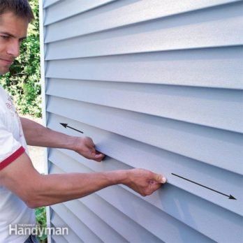 a man is trimming the side of a house