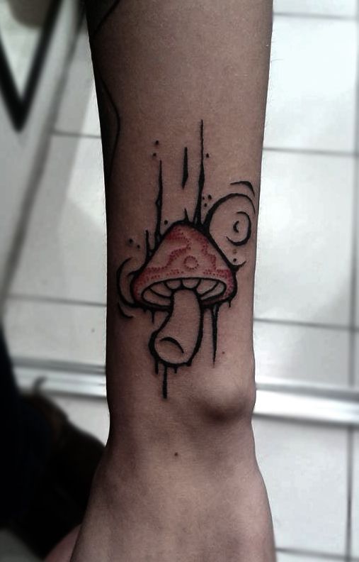 a small mushroom tattoo on the arm