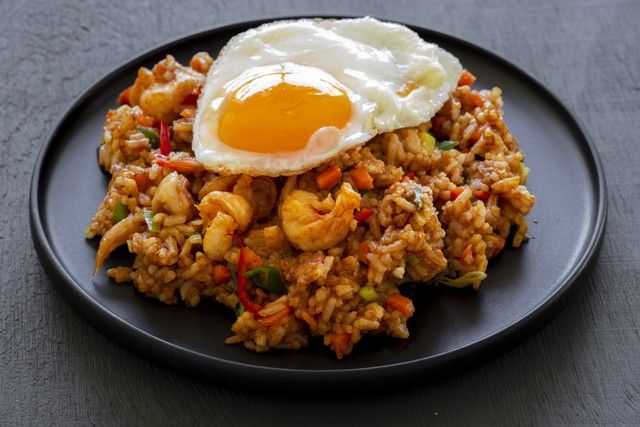 an egg is sitting on top of some fried rice