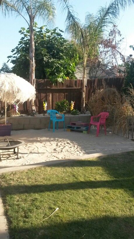 a backyard with lawn chairs and an umbrella