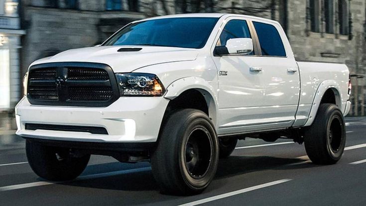 a white ram truck driving down the road