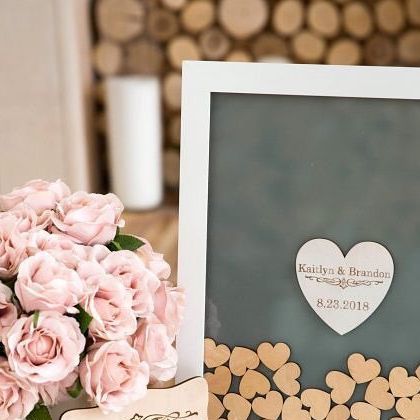 a bouquet of pink roses sitting on top of a table next to a framed photo