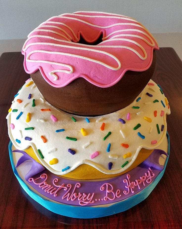 three donuts stacked on top of each other with frosting and sprinkles