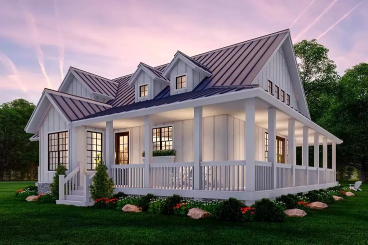 a white house sitting on top of a lush green field next to a forest at dusk