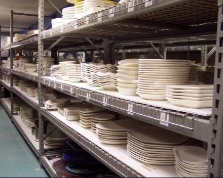 stacks of white plates on shelves in a store