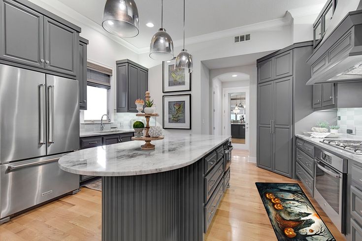 a large kitchen with stainless steel appliances and wood flooring is pictured in this image