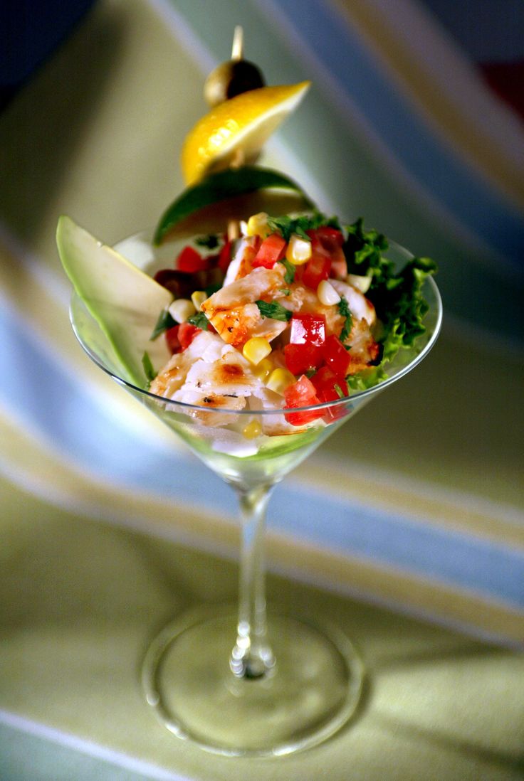 a martini glass filled with salad and garnish