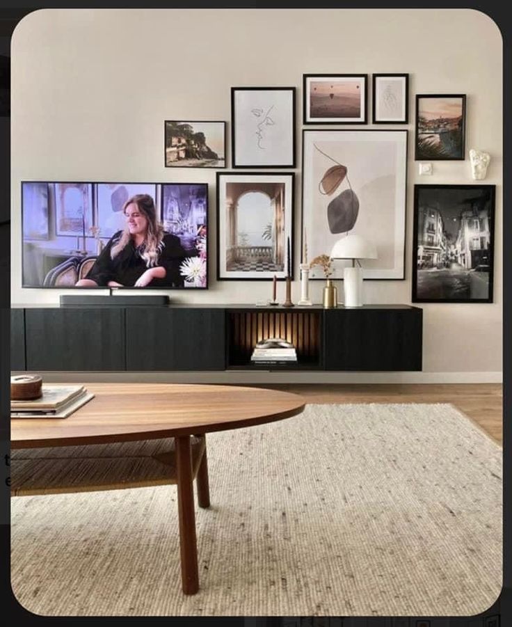 a living room with pictures on the wall and a table in front of an entertainment center