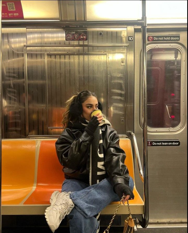 a woman sitting on a subway bench eating an apple