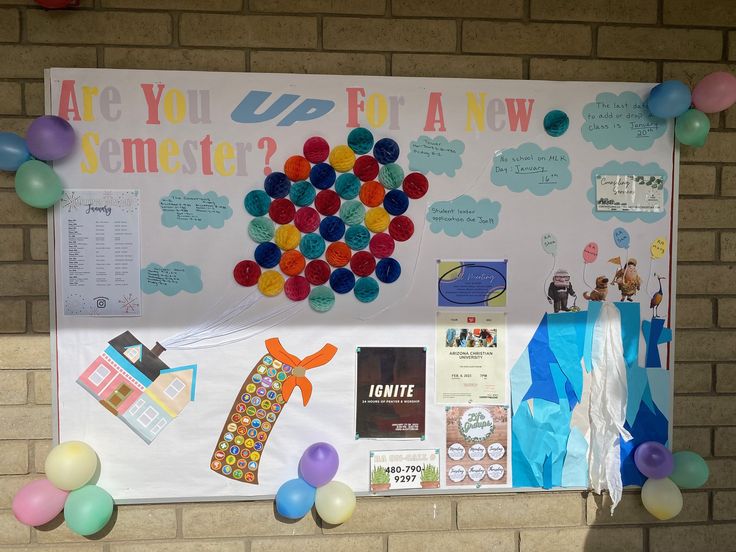 the bulletin board is decorated with balloons and other things to be displayed on it's side