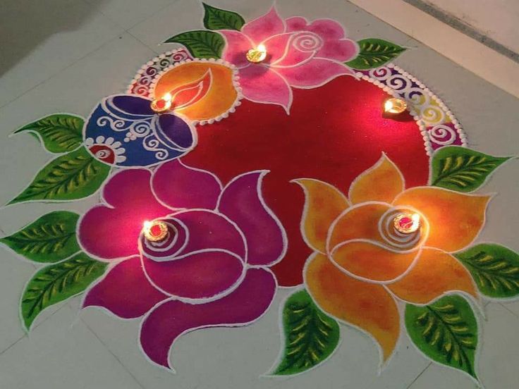 a decorated floor with candles on it and flowers painted on the ground in different colors