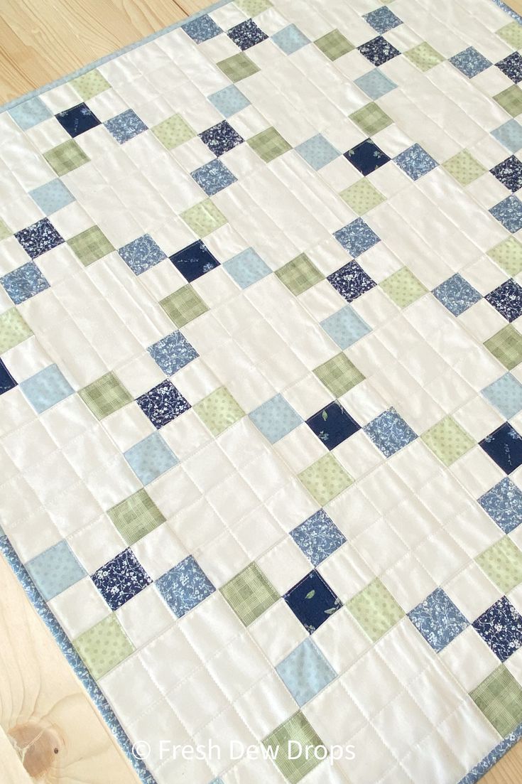 a blue and green patchwork quilt on the floor