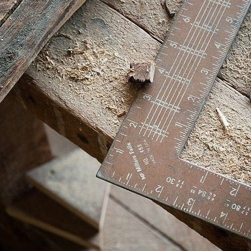 an old wooden ruler sitting on top of a piece of wood