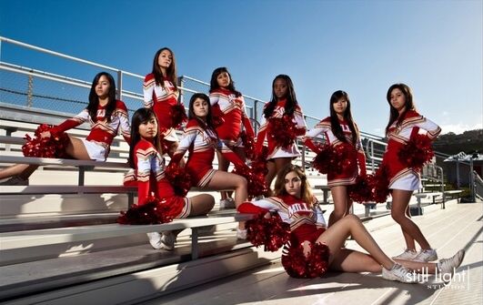 a group of cheerleaders posing on the bleachers in red and white outfits