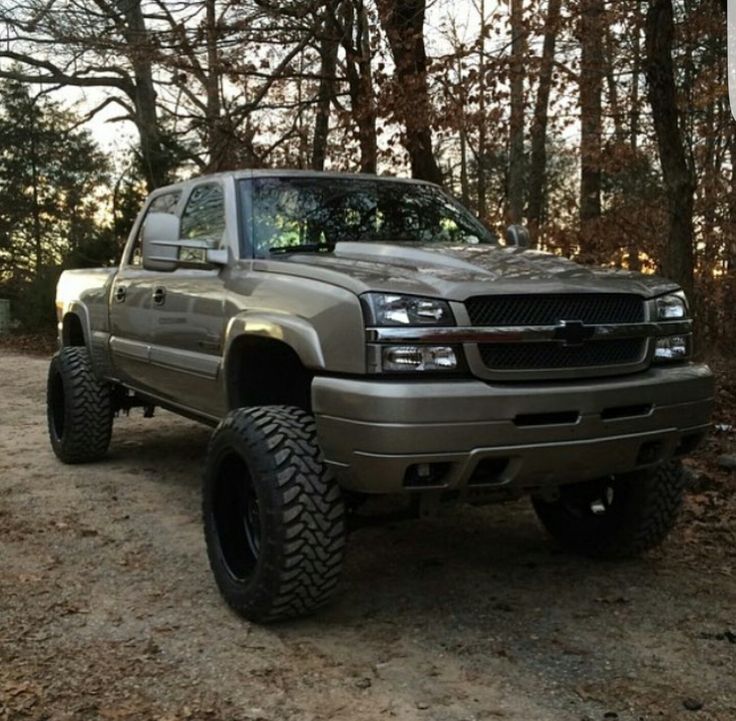 a silver truck parked on top of a dirt road