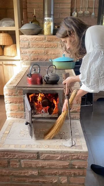 a woman is cleaning the fire with a broom