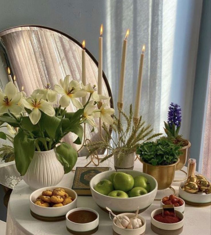 a white table topped with bowls filled with fruit and veggies next to a mirror