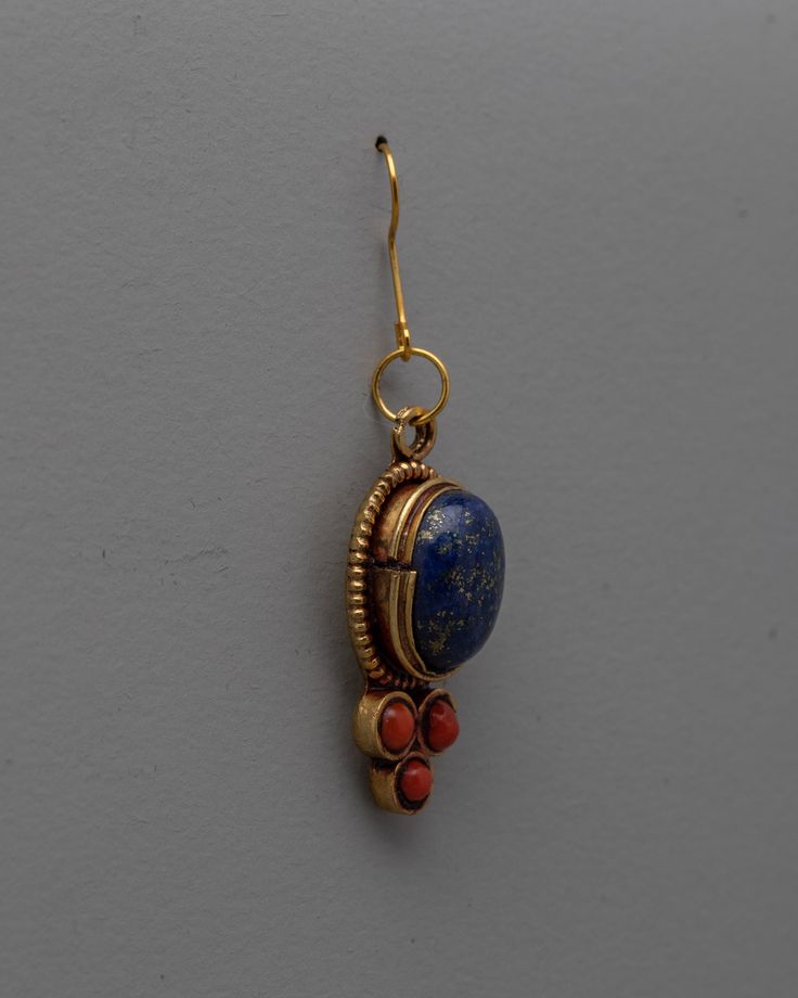 Dangle Gemstone Earrings About our product: The Dangle Gemstone Earrings, handcrafted on a copper and brass body with electro-gold plating, are a breathtaking example of beauty and craftsmanship combined. The exquisite inlay of semi-precious stones, such as coral and lapis lazuli, accentuates the beauty and allure of these earrings. Any ensemble is given a sophisticated and colorful pop when the coral stones' vivid red contrasts with the lapis lazuli's rich blue. These Dangle Gemstone Earrings a Gold Lapis Lazuli Gemstone Earrings, Gold Earrings With Natural Lapis Lazuli Stones, Gold Lapis Lazuli Drop Earrings, Bronze Gemstone Brass Jewelry, Bronze Brass Jewelry With Gemstone, Handmade Gold Lapis Lazuli Earrings, Handmade Gold Earrings With Lapis Lazuli, Bronze Dangle Earrings With Natural Stones, Handmade Brass Drop Earrings