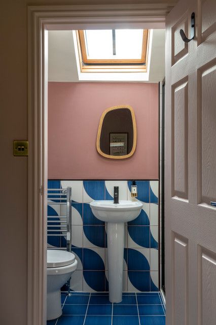 an open door leading to a bathroom with pink walls and blue tiled flooring on the wall