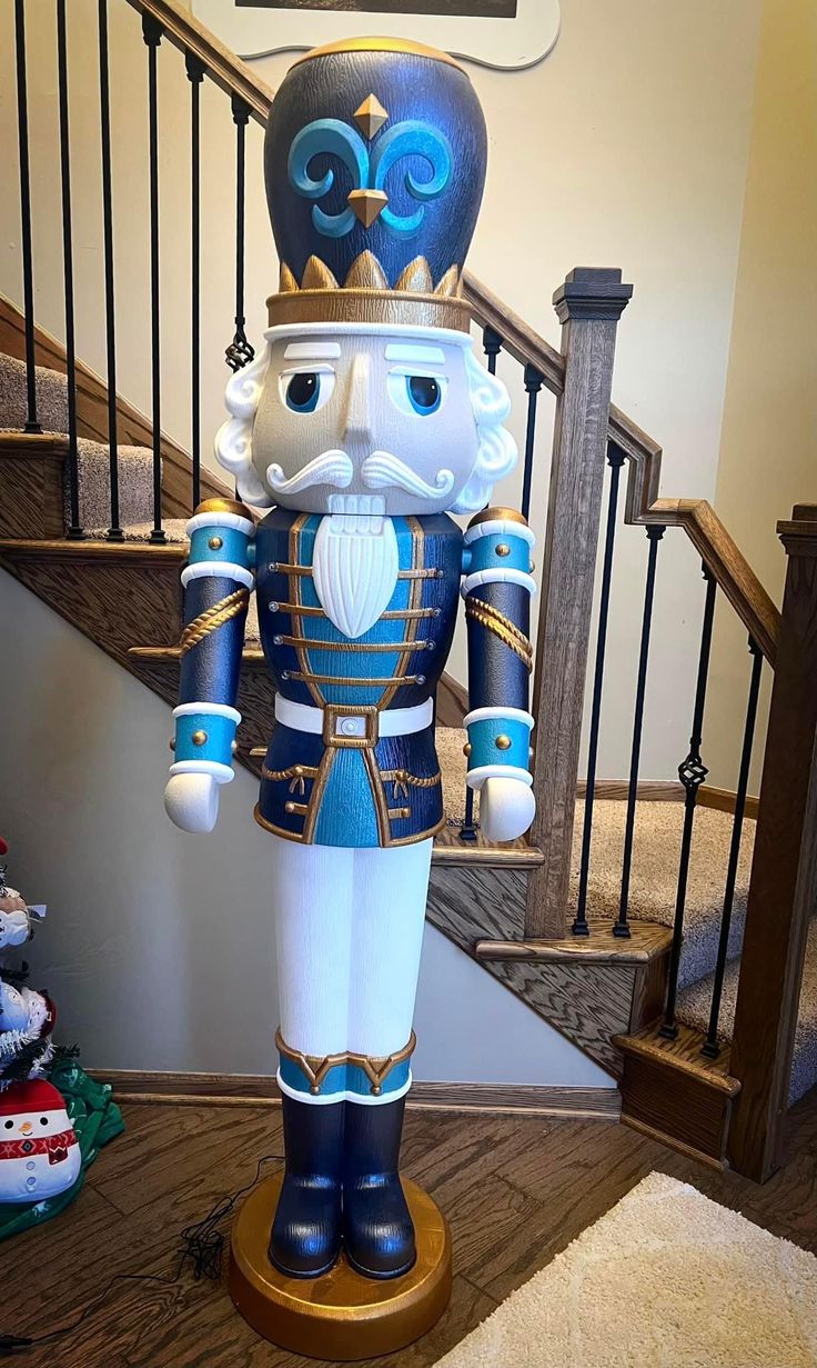 a statue of a nutcracker stands in front of stairs