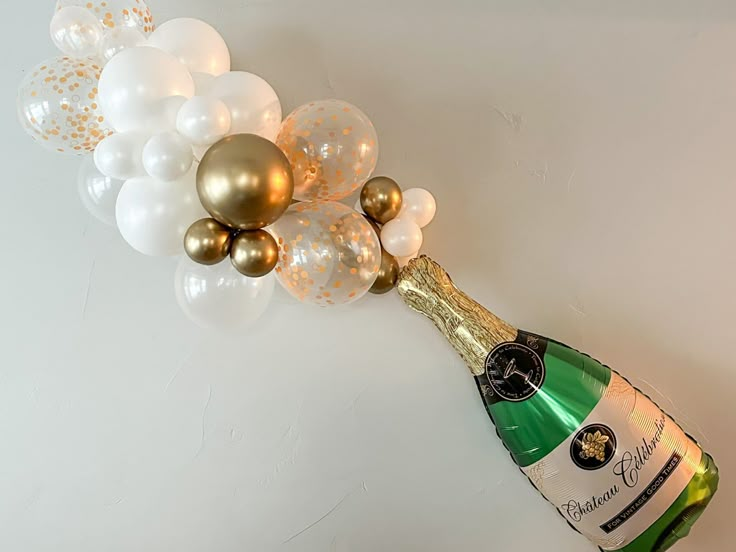 a bottle of champagne and some balloons on the wall