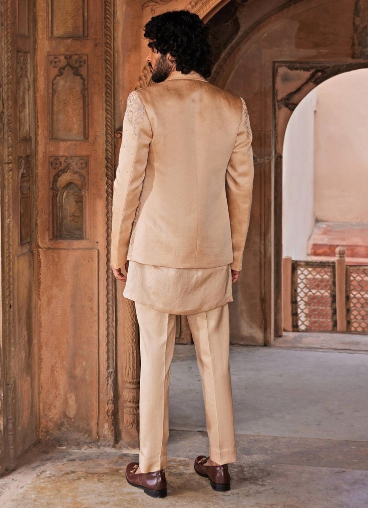 Elevate your formal wardrobe with the luxurious Beige Embroidered Kurta Jacket Set, crafted from premium linen silk. The heavily embroidered beige jacket showcases intricate floral motifs, embellished with crystals, zardozi, cutdana, and dabka work, blending traditional craftsmanship with modern elegance. Paired with a matching panel-detail kurta and tailored pants, this ensemble creates a cohesive, sophisticated look. The soft, breathable fabric ensures comfort while exuding refined sophistication. Perfect for Mehndi, Sangeet, or weddings, this set promises to make a lasting impression with its exquisite detailing and timeless appeal. Composition : Jacket, Kurta and Pants - Linen SilkCare: Dry Clean Only and Vacuum Storage Delivery : 4-6 weeks as the product is hand crafted. Check Size Gu Elegant Raw Silk Nehru Jacket With Traditional Drape, Elegant Nehru Jacket In Raw Silk With Traditional Drape, Elegant Raw Silk Nehru Jacket For Festive Occasions, Silk Nehru Jacket With Intricate Embroidery For Weddings, Elegant Silk Nehru Jacket For Designer Wear, Elegant Raw Silk Nehru Jacket With Zari Work, Elegant Nehru Jacket In Raw Silk With Zari Work, Elegant Silk Nehru Jacket With Traditional Drape, Elegant Silk Nehru Jacket In Traditional Drape