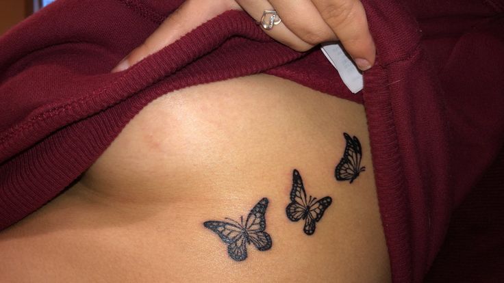 a woman's stomach with three butterflies on it