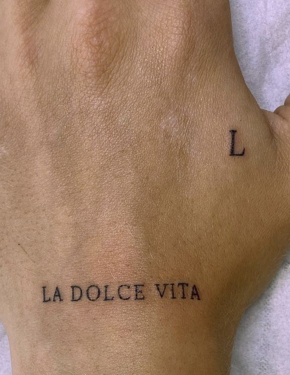 a person's foot with the word la dolce vita tattooed on their left side