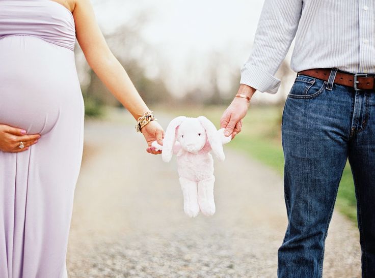 a pregnant woman holding the hand of her husband