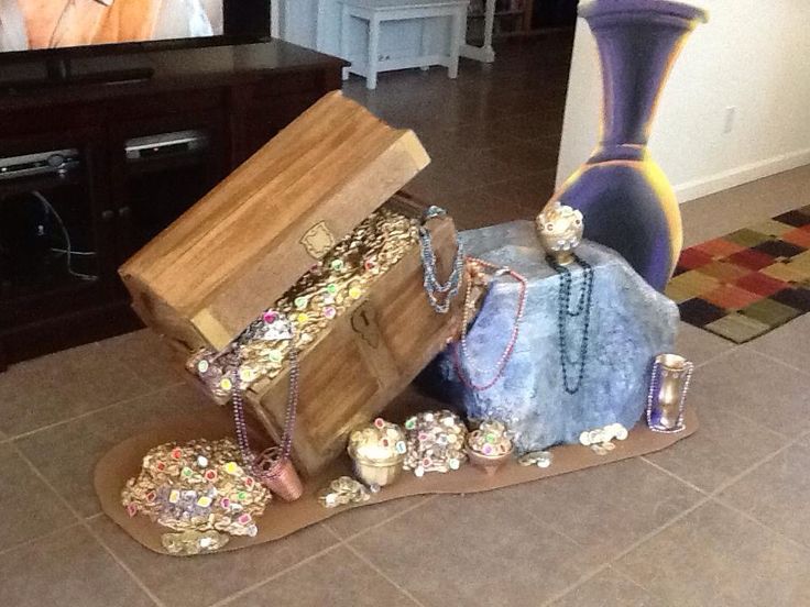 an open suitcase sitting on the floor next to a vase and other items in front of a flat screen tv