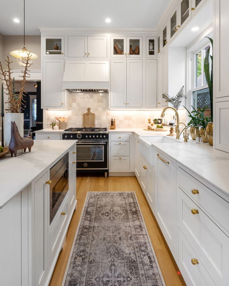 a kitchen with white cabinets and an area rug on the floor in front of the stove