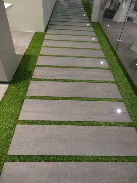 the walkway is lined with artificial grass and lit up by led lights on either side