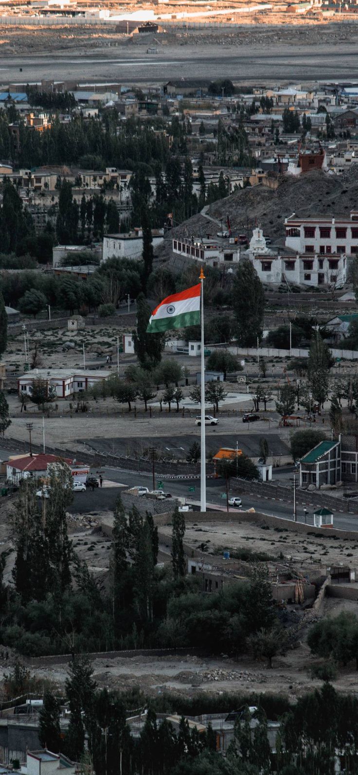 an aerial view of a town with a flag in the foreground