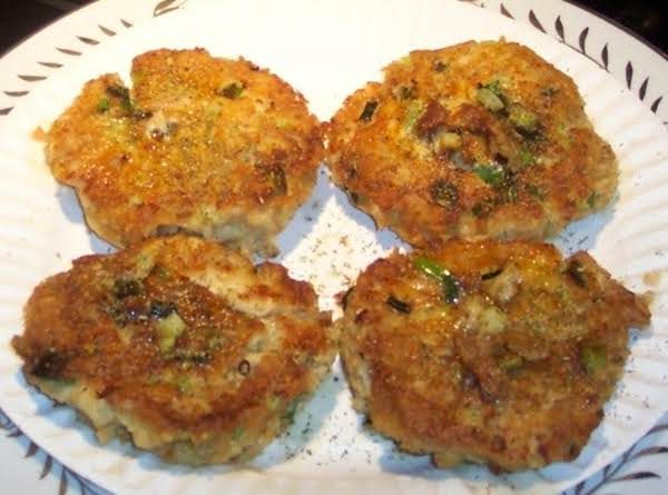 four crab cakes sitting on top of a white plate