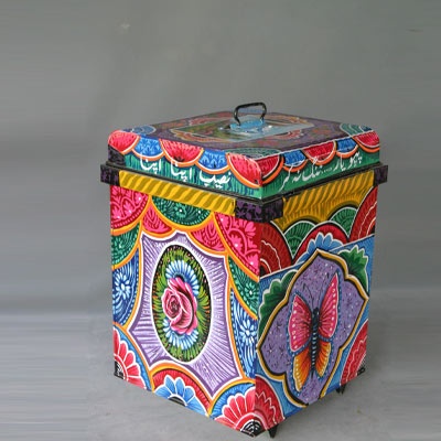 a colorful painted box sitting on top of a white table next to a gray wall