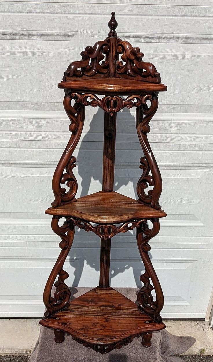 an ornate wooden shelf sitting in front of a garage door