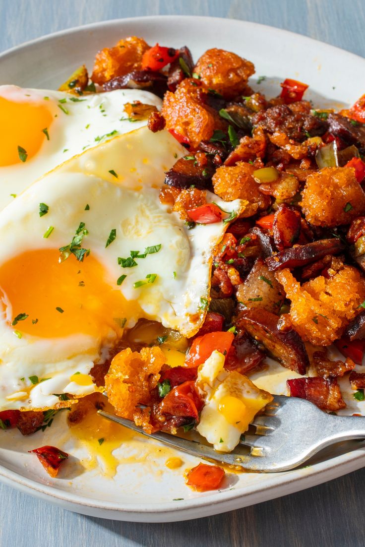 two fried eggs are on a plate with other food