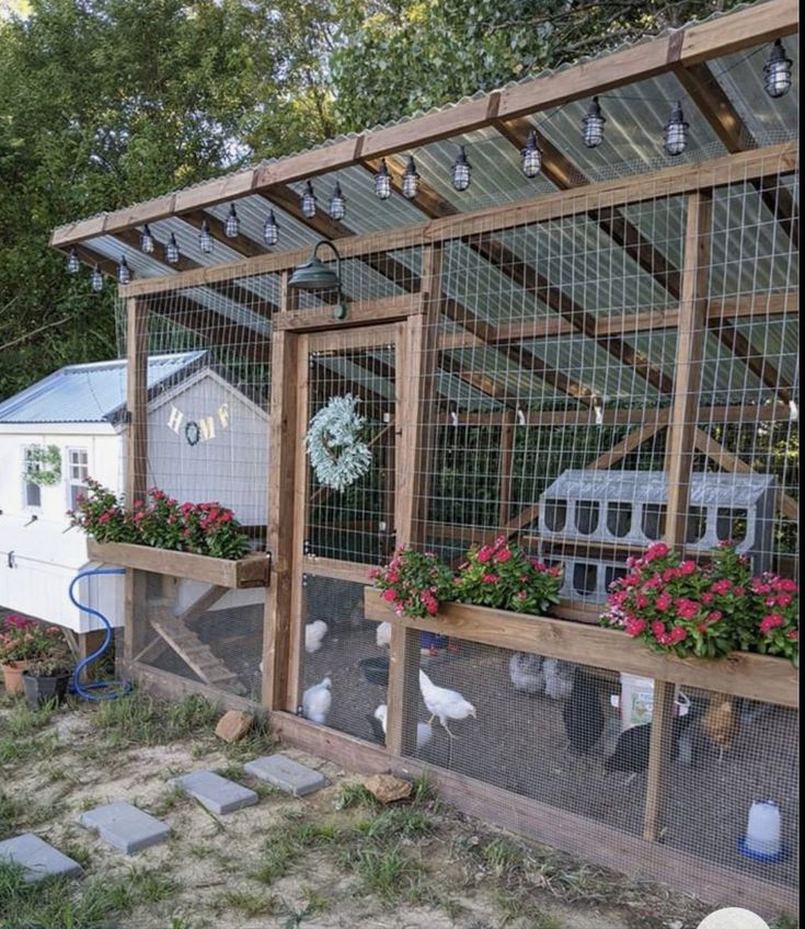 a chicken coop with flowers and chickens in it