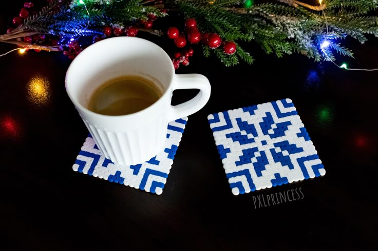 a cup of coffee sitting on top of a wooden table next to a christmas tree