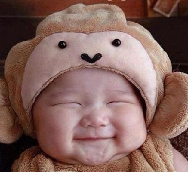 a baby wearing a monkey hat with the words happy birthday written in large white letters