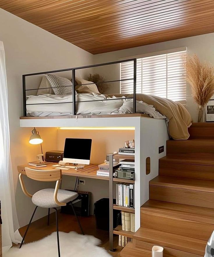 a loft bed with desk underneath it and stairs leading up to the upper level,