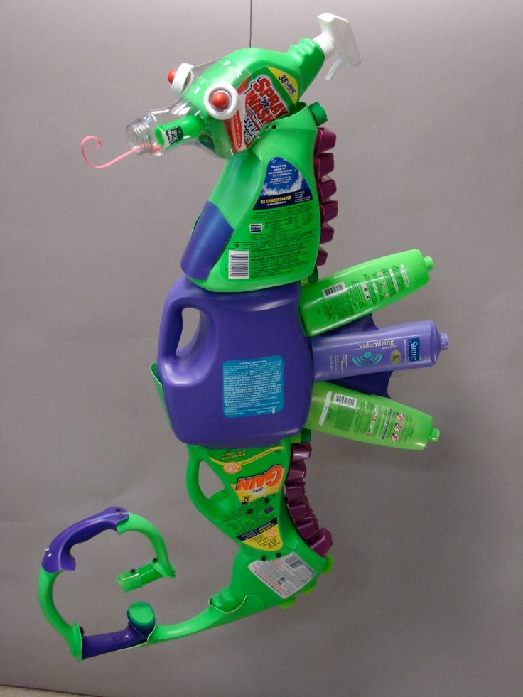 a green and purple toy with toothpaste on it's back hanging from a hook