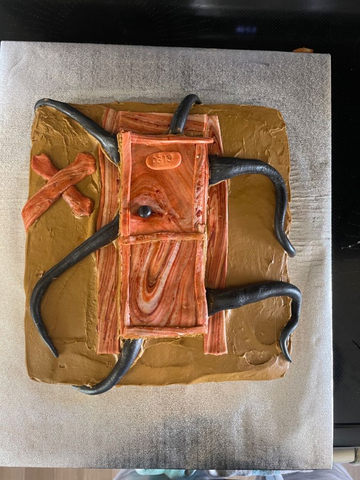 a cake that looks like a computer mouse on top of some brown icing and black piping