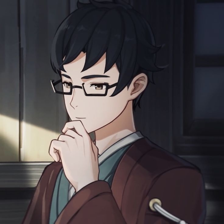 a man with glasses is looking at something in front of him and has his hand on his chin