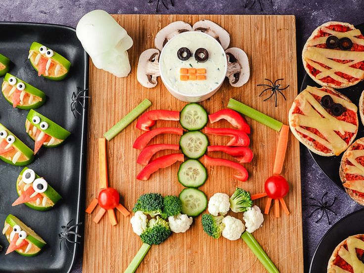 a wooden cutting board topped with veggies and cut up animals on top of it