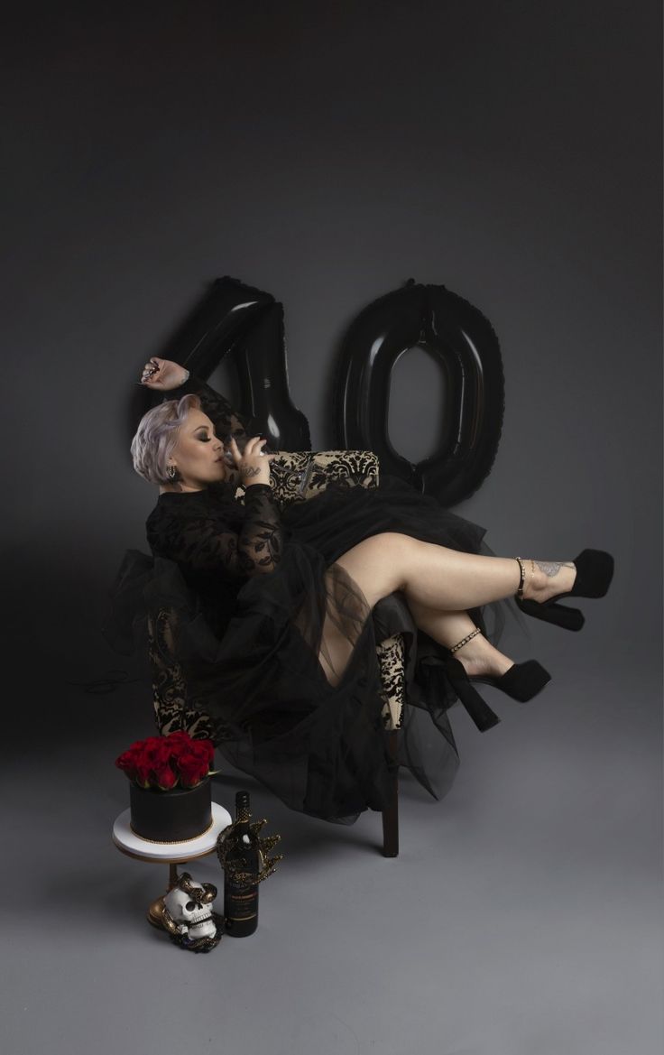 a woman sitting on top of a chair next to a cake and an air balloon