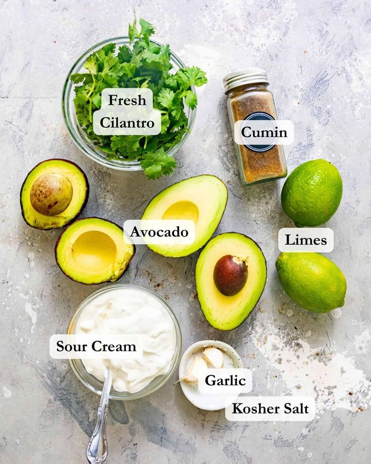 the ingredients for an avocado salad laid out on a table