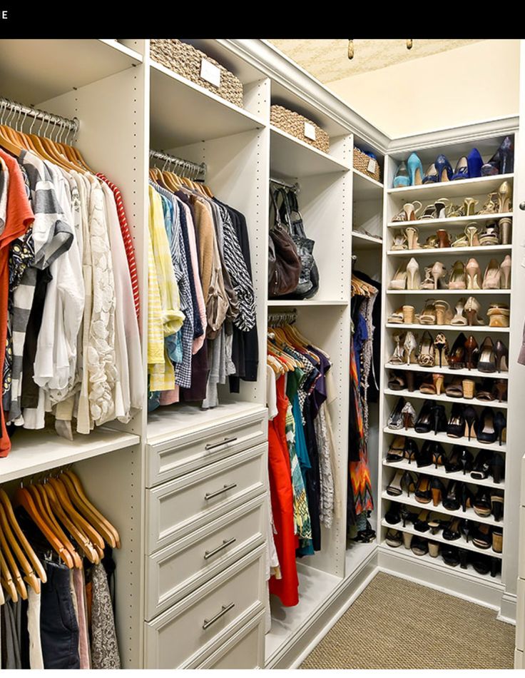 an organized closet with white shelving and lots of shoes