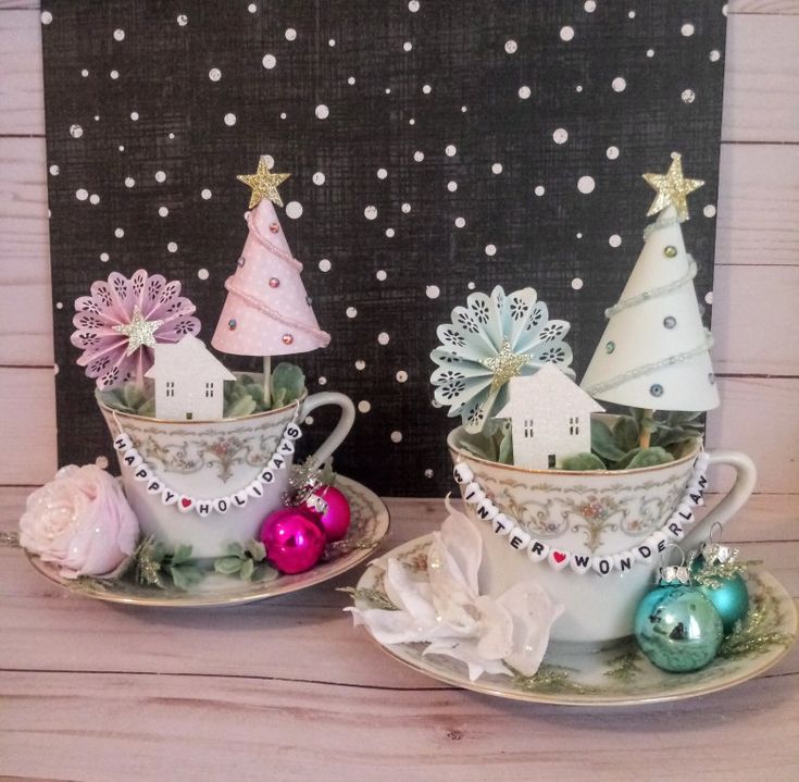 two tea cups decorated with christmas trees and ornaments